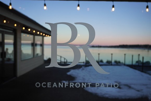 Bayside Logo on a glass door looking onto our patio during blue hour